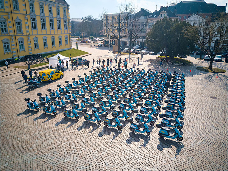 Die E-Roller-Flotte von EWE Go sind auf dem Schlossplatz in Oldenburg aufgereiht.